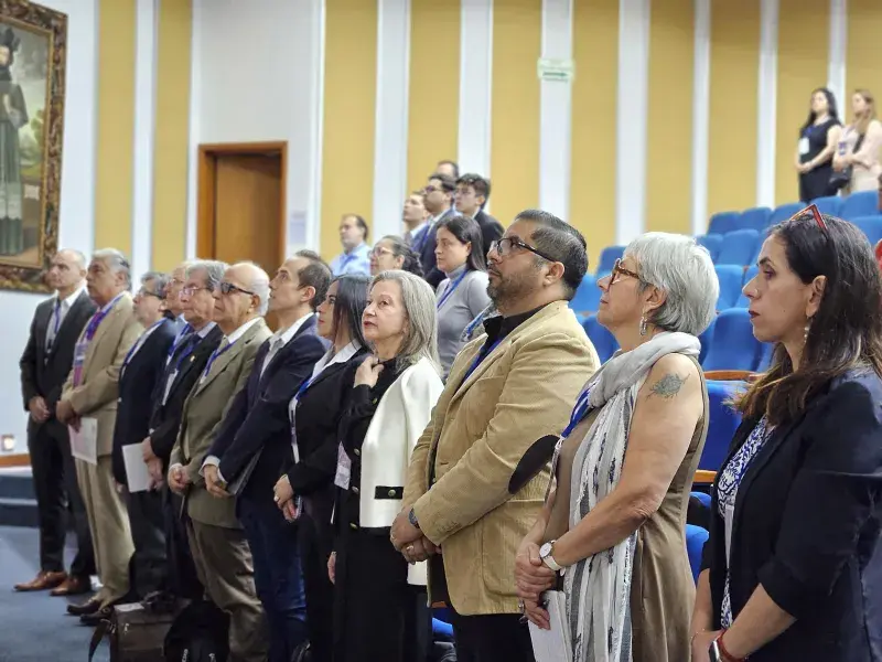 Conferencistas y panelistas Líderes de la salud, la academia y el gobierno de pie presenciando el II Foro Andino Por la Salud de Ellas, en el Auditorio Los Almendros de la Javeriana Cali